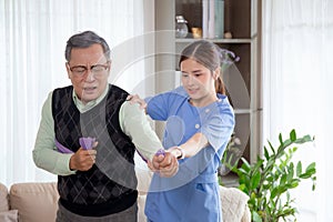 Asian caregiver woman or nurse training senior man stretch arm for exercise while therapy and rehabilitation.