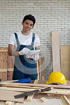 Asian carpenter inspect the list of items that must be done as scheduled