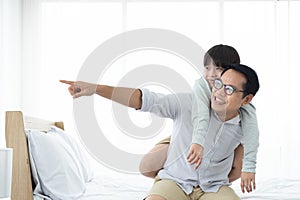 Asian carry back son on bed,happy family at home