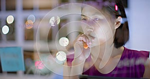 Asian casual businesswoman using tablet brainstorming, making notes on glass wall at night in office