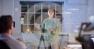 Asian casual businesswoman using tablet and glass wall presenting to colleagues at night in office