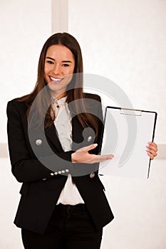 Asian caucasian busines woman writing on a clipboard