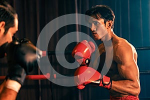 Asian and Caucasian Muay Thai boxers exchanging punch. Impetus