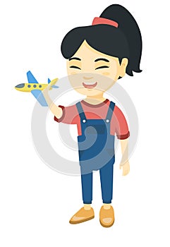 Asian cheerful girl playing with a toy airplane