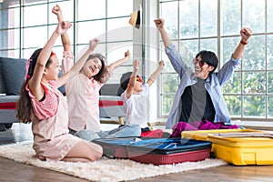 Asian cheerful happy family mom dad son and daughter raising hands up smiling laughing celebrating holiday preparing packing