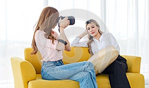 Asian cheerful happy pride proud female lesbian LGBTQ sitting talking with lover couple trying using testing digital DSLR camera