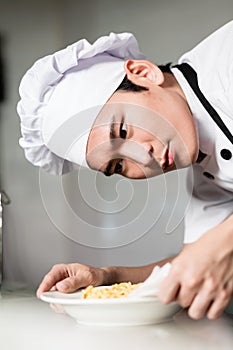 Asian chef plating up a bowl of food