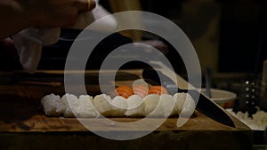 Asian cheff prepare the slice of raw fish for make sushi in kitchen of Japan