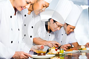 Asian Chefs in restaurant kitchen cooking