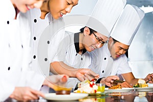 Asian Chefs in restaurant kitchen cooking