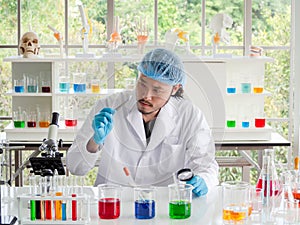 Asian chemist researcher looking at a tablet at laboratory, The scientist checking medicine.