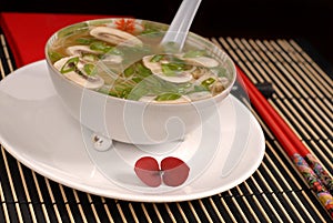 Asian chicken, glass noodle and rice soup with mushrooms and scallions photo