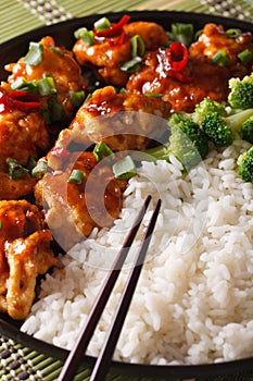 Asian Chicken tso with rice and broccoli close-up. vertical