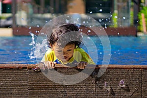 Asian child boy learn swimming in a swimming pool