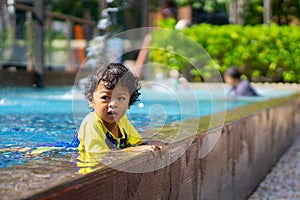 Asian child boy learn swimming in a swimming pool