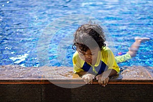 Asian child boy learn swimming in a swimming pool