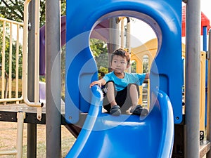 Asian child boy playing in playground. Young kid having happy moment in summer.