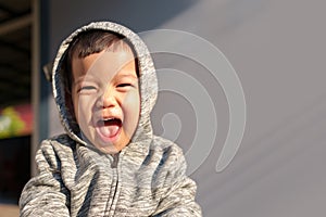 Asian child boy waering hooded sweater having fun