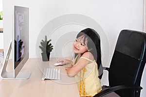 Asian Child Cute and happy little girl children using  computer, studying through online e-learning system