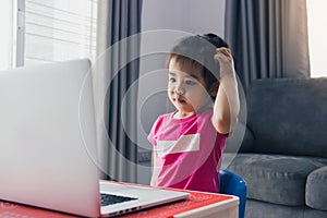 Asian child is dazed by the teachings of online students at home