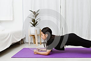 Asian Child doing yoga Plank at home