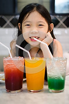 Asian Child Drinking Juice or Fruit Beverage from Glass