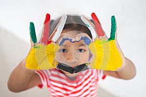 Asian child girl with colorful painted hands make heart shape with fun and love