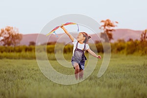 Asian child girl and father with a kite running and happy on meadow in summer in nature