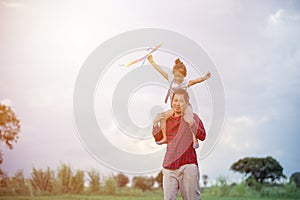 Asian child girl and father with a kite running and happy on meadow in summer in nature