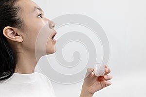 Asian child girl gargling with an antiseptic,protect against the Coronavirus COVID-19 in throat,disinfection prevention of oral