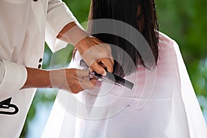 Asian child girl getting haircut by grandmother at home