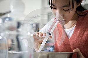 Asian child girl having stuffy nose,difficulty breathing,nasal wash,nose cleaning with syringe and saline,nasal sinus infection,