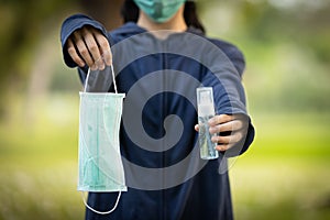 Asian child girl hold a mask and bottle of alcohol disinfectant or alcohol antiseptic gel to prevent infection of Covid-19,