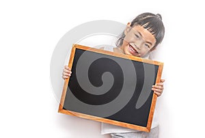 Asian child girl holding the small blank blackboard or chalkboard. Back to school concept. Child wearing white cloth. Looking at