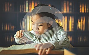 Asian child girl industrious is sitting at a desk indoors. Kid is learning in home photo