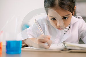 Asian child girl learning science chemistry with test tube making experiment at school laboratory. education, science, chemistry,