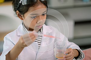 Asian child girl learning science chemistry with test tube making experiment at school laboratory. education, science, chemistry,