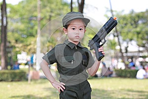 Asian child girl in pilot soldier suit costume with shooting gun up. Dream job concept