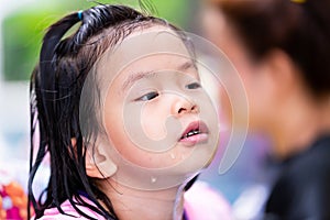 Asian child girl playing water in the pool with family. Happy face kid enjoying with travel in holiday. Summer day.