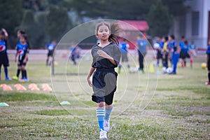 Asian child girl running and exercise warm up before play soccer in the field.