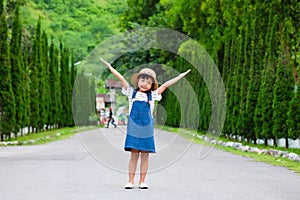 Asian child girl smiling with her arms raised on both sides of the road