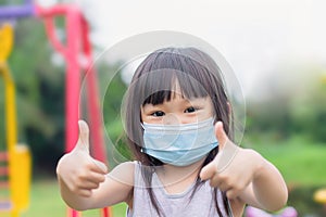 Asian child girl smiling and wearing face mask