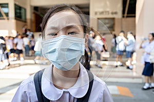 Asian child girl student wearing protective medical face mask in school,epidemic,spread of Coronavirus,Covid-19,schoolgirl with