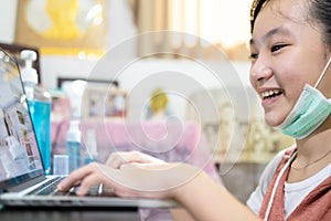 Asian child girl studying using laptop computer,online education during the pandemic of Covid-19,Coronavirus,student learning