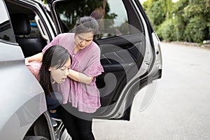 Asian child girl about to throw up from car sick or indigestion,female teenage vomiting in a car suffers from motion sickness, photo