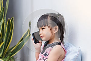 Asian child girl watching and using smart phone.