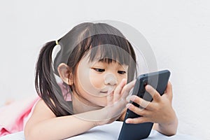 Asian child girl watching and using smart phone.