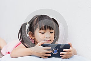 Asian child girl watching and using smart phone.