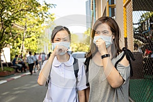 Asian child girl wearing medical mask in public area at risk of disease,people with mask  in city street prevent infection from