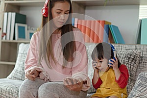 Asian child having fun and dancing with her mother in a room, active leisure and lifestyle concept